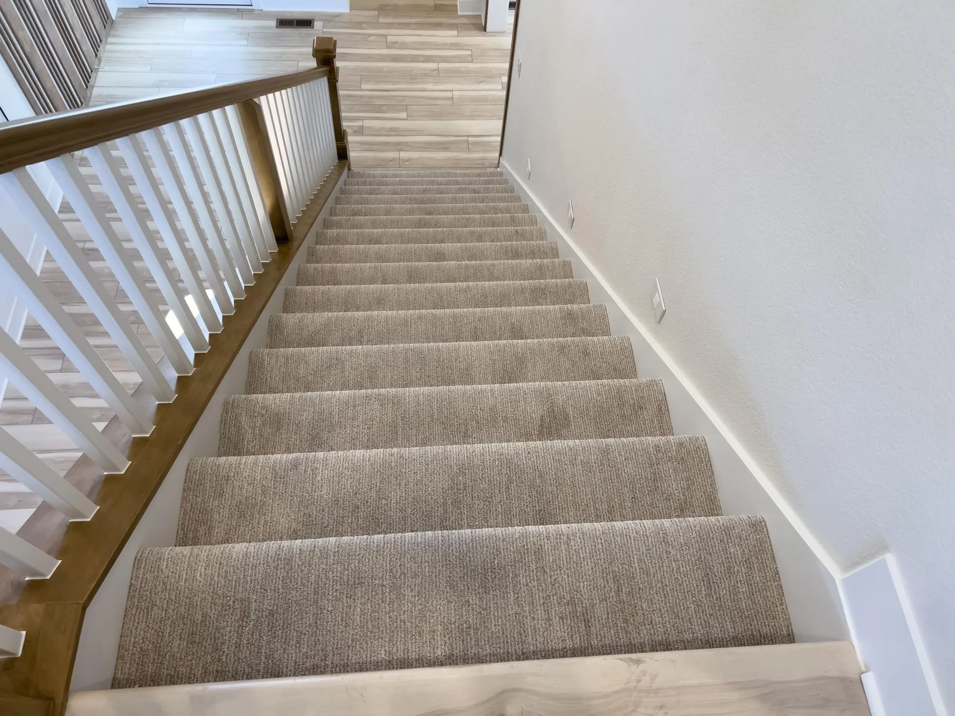 The stairs are carpeted and have a wooden railing.