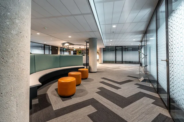 A hallway in an office building with a chevron pattern on the floor.