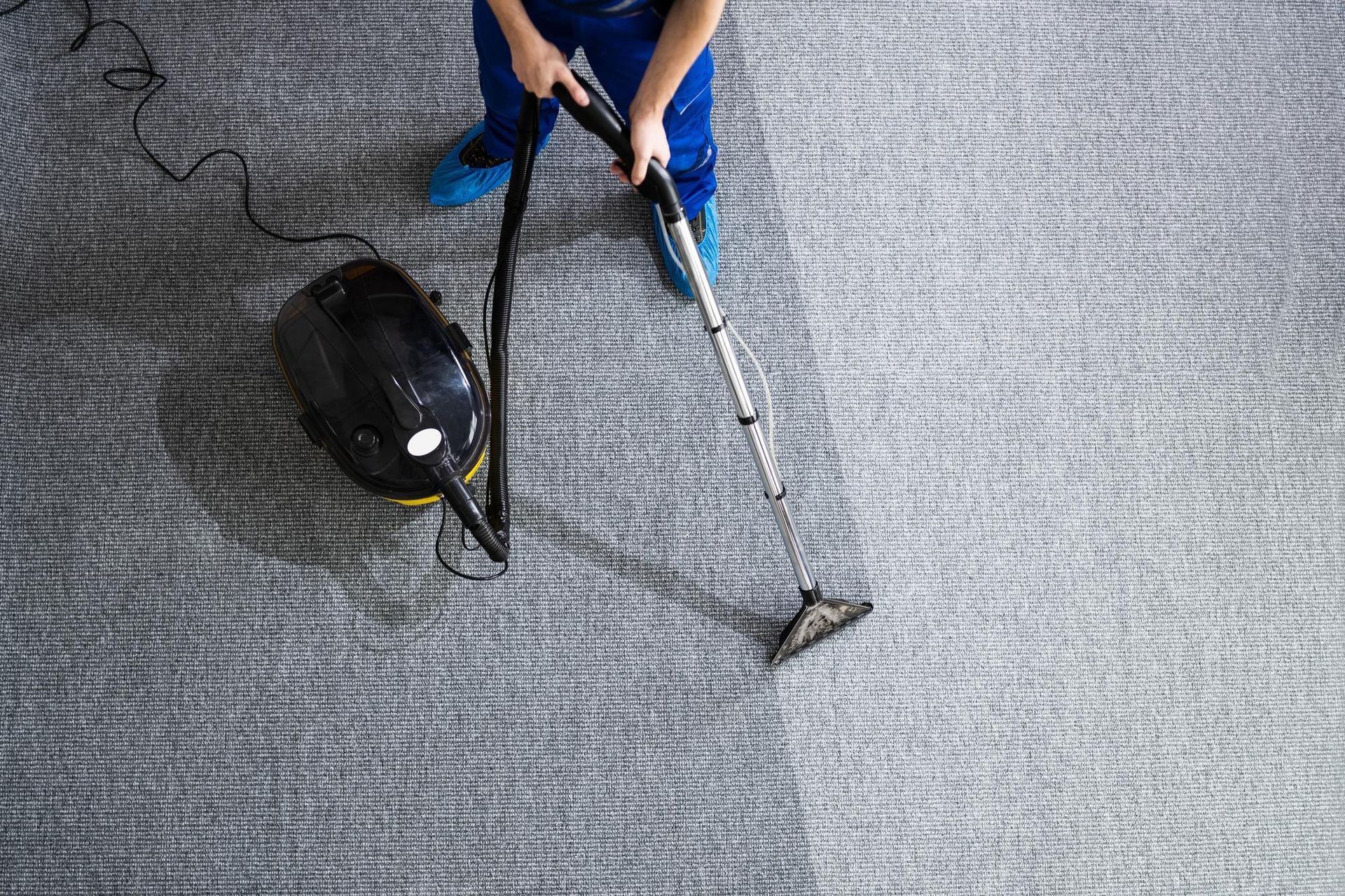 A person is cleaning a carpet with a vacuum cleaner in a church.
