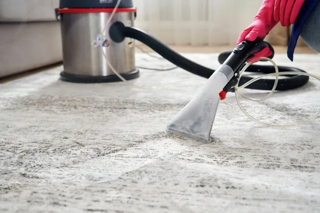 A person is restoring a carpet with a vacuum cleaner.