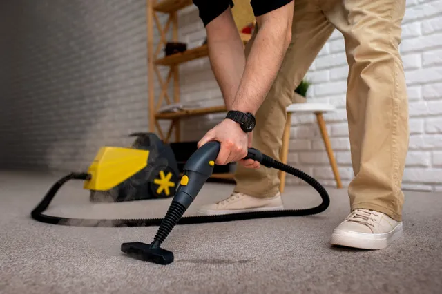 A man is cleaning a carpet deeply with a steam cleaner in Vancouver.