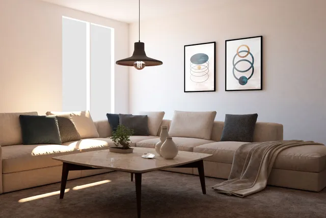 Beige sectional sofa in a living room with a coffee table, art, and a hanging light.