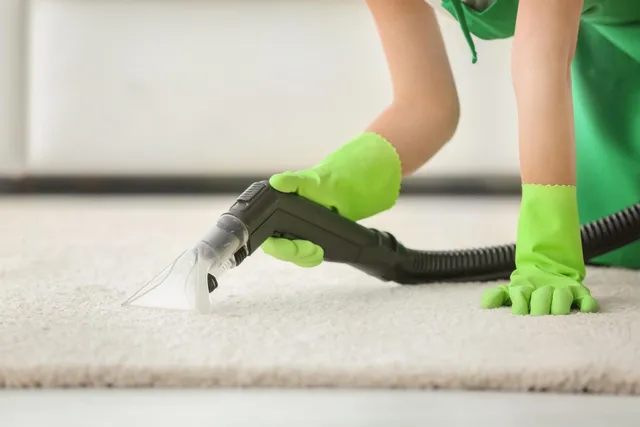 A woman is doing deep carpet cleaning with a vacuum cleaner.