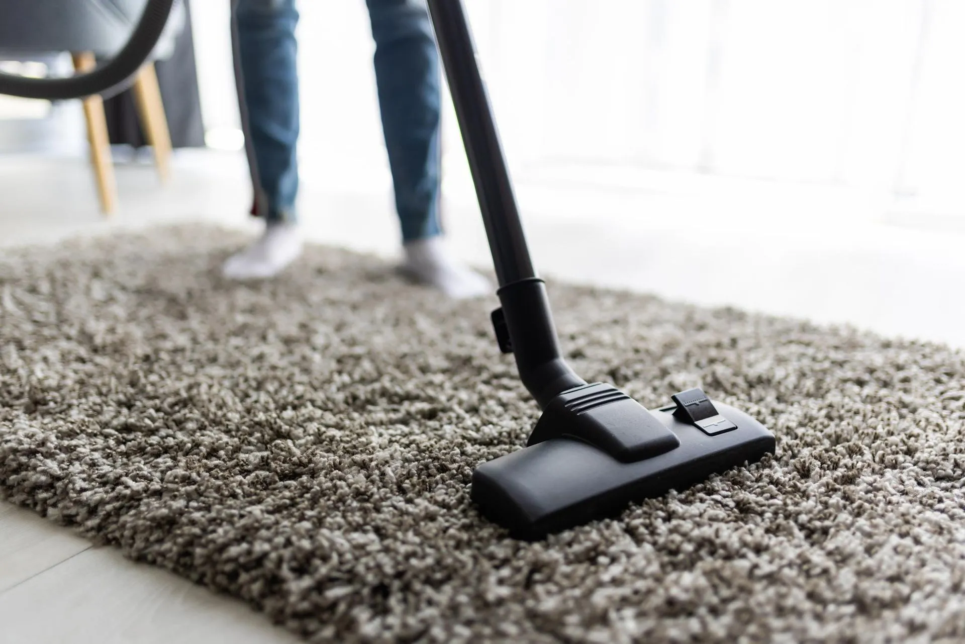 A person is using a vacuum cleaner for organic carpet cleaning in Vancouver.