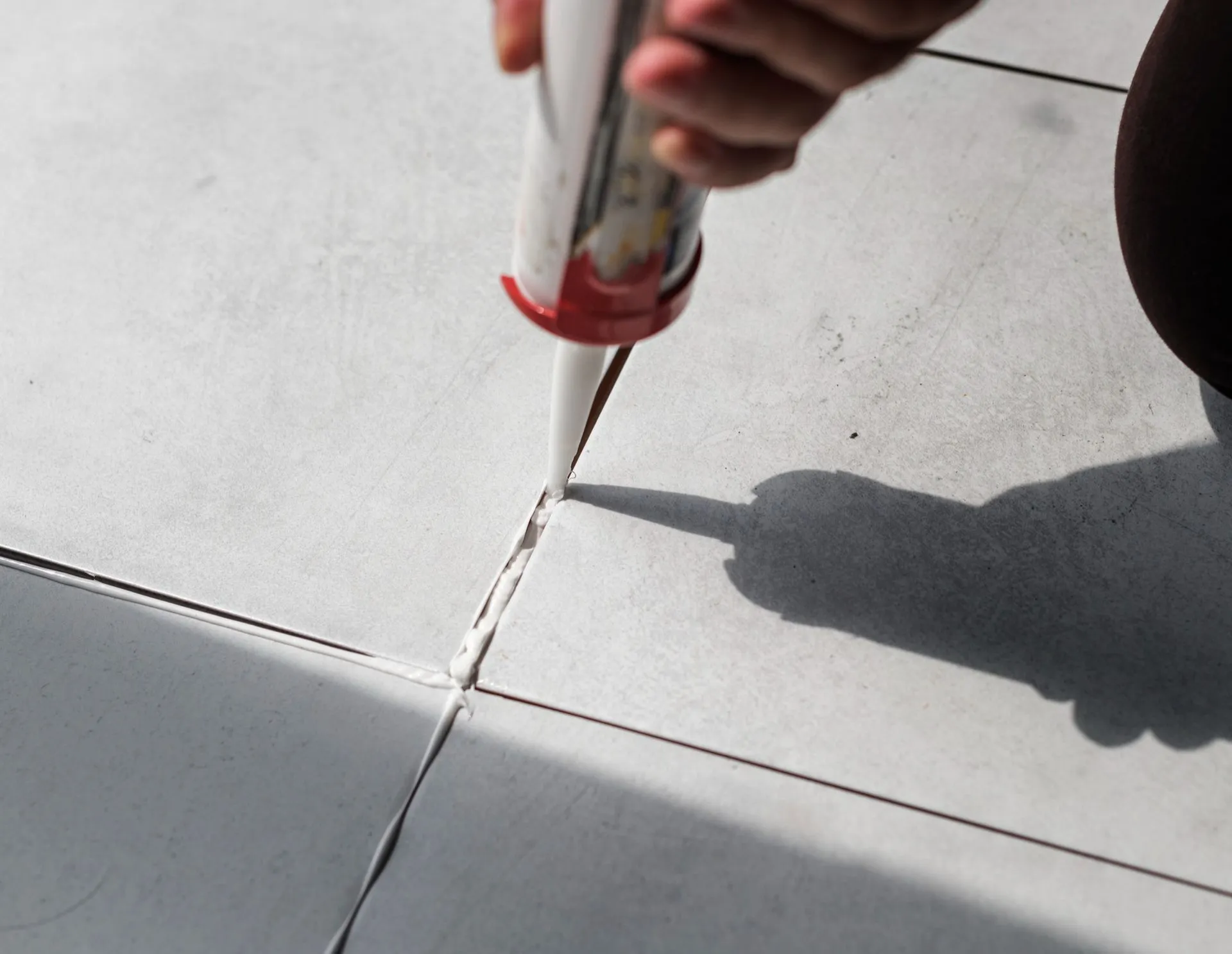 A person is applying a sealant to a tile floor for tile grouting in Vancouver
